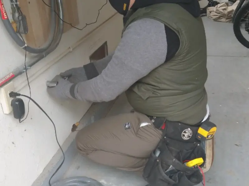 Electrician performing outlet wiring in a Ho-Ho-Kus garage